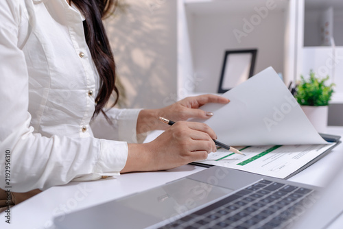 Business professional organizing documents, reviewing information and managing daily office tasks to support efficient workflow, planning and business operations in a modern workplace.