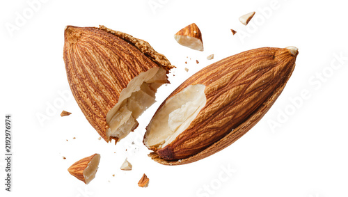 Фотография Cracked almond with shell fragments flying, isolated on transparent background