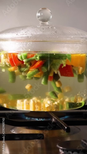 Boiling and blanching mixed vegetables in a transparent glass pot