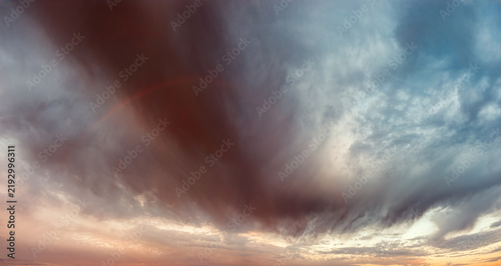 Obraz premium Panoramic Rainbow and Dramatic Storm Clouds at Sunrise After Rain
