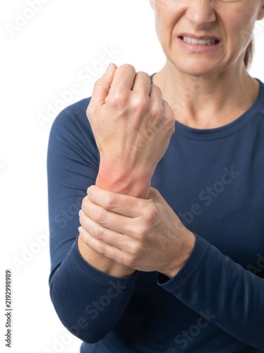 Middle-aged woman suffering from wrist pain, holding her hand with visible redness and a pained expression, isolated on white background