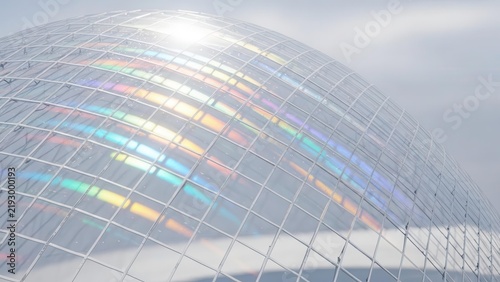Sunlight creating vibrant rainbow reflections on a modern glass dome structure with a grid pattern.