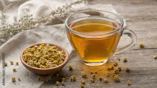 Amber Herbal Tea in a Clear Glass Cup with Dried Chamomile