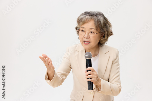 Obraz na płótnie Senior Asian Woman Giving a Speech with Microphone