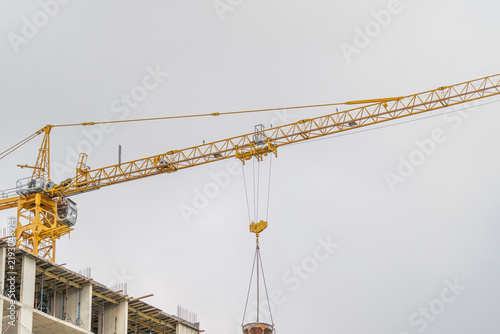 Konstfotografi Construction crane dominates the skyline during a cloudy day showcasing urban pr