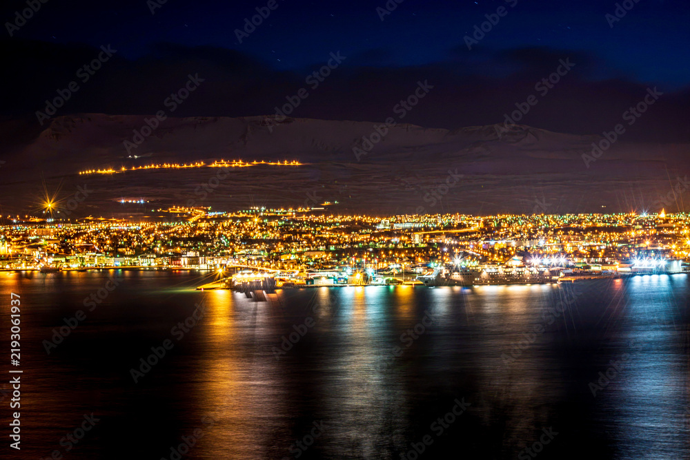 Fototapeta premium Night lights of Akureyri city reflected in the fjord, Iceland