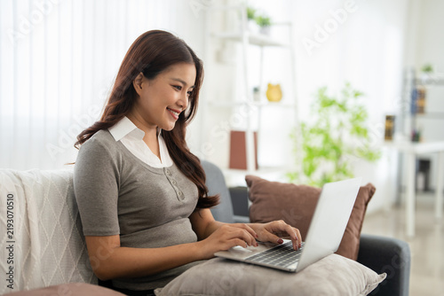 Woman self employed working online using computer at home.