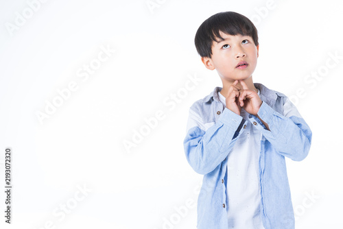 Thoughtful Young Boy Looking Up with Hand on Chin