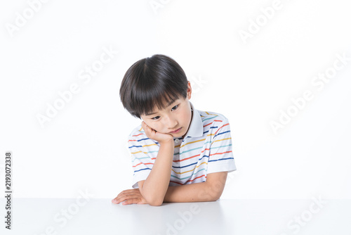 Bored Young Boy Sitting at a Desk Looking Thoughtful