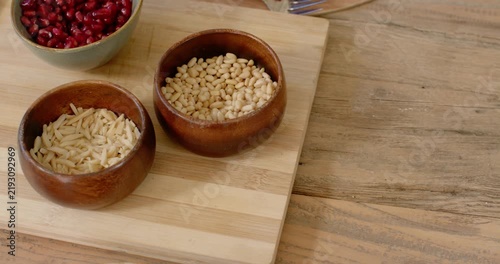 Camera is panning right and down, centering two wooden bowls on cutting board for prep