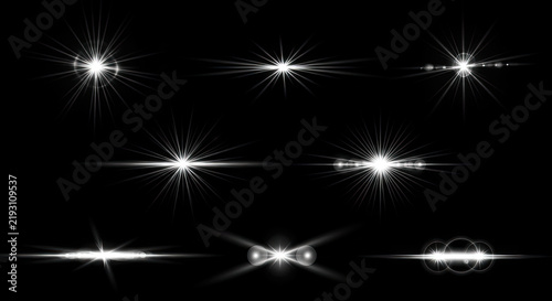 A collection of white light rays emanates from several bright points against a stark black background. The rays create a dynamic and shimmering effect, suggesting intense illumination and energy.