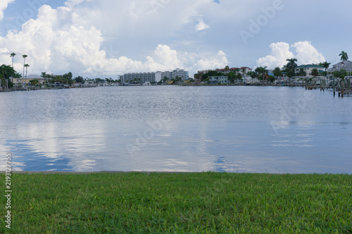 Obraz na płótnie A calm waterfront bay scene showing residential homes, boat docks and palm trees with soft water reflections