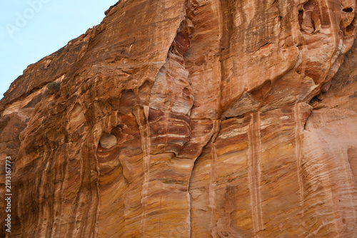 Bild auf Leinwand Textured sandstone cliffs with layered striations under bright daylight