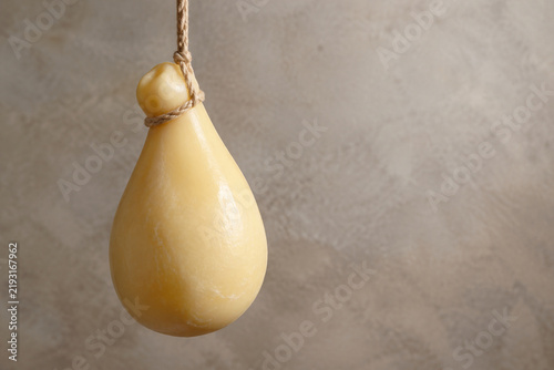 Картината върху платно Pear-shaped scamorza cheese hanging on rope, artisanal food still life