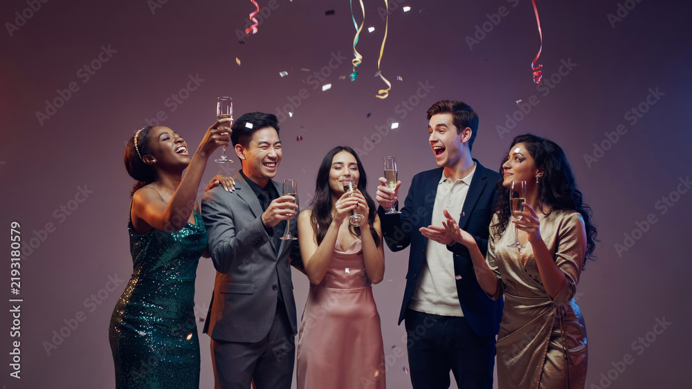 Fototapeta premium A group of diverse people celebrating with champagne and confetti.