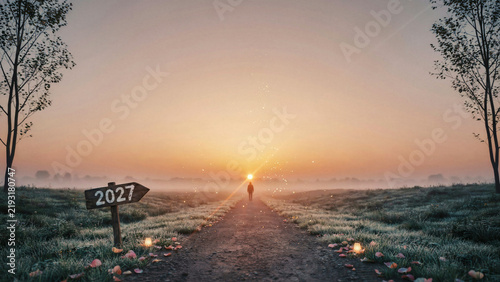 A lone figure walks down a path towards a sunrise in 2027.
