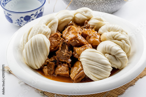Fotografie Pot-roasted chicken and small steamed buns arranged on a white background