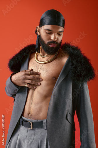 Obraz na plátne Young man showcases stylish fashion with confidence against a striking backgroun