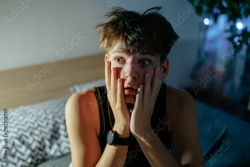 Fotografie Close up of a restless teenage boy experiencing a panic attack at night