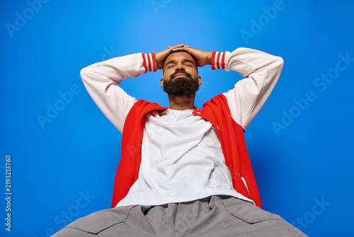 Obraz na plátně Young handsome african american man expresses style and confidence against a vib