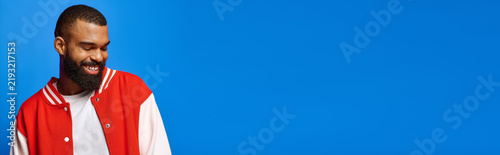Fotografía Stylish young man radiates confidence against a vibrant blue backdrop