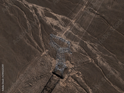 aerial view of high voltage power transmission tower in desert landscape