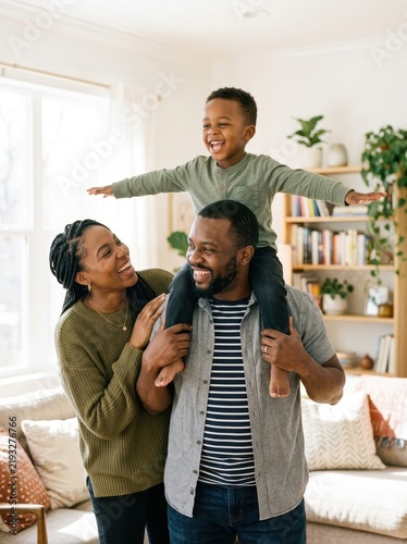 Happy African American Family with Young Son Playing and Laughing Together in Bright Living Room