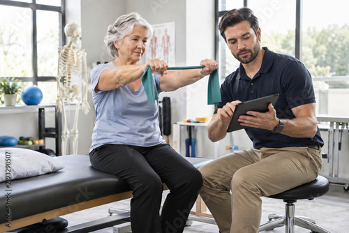 Male occupational therapist using modern technology during