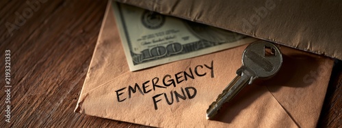Envelope Containing Cash and Key for Emergency Fund Beside Household Items on Wooden Surface
