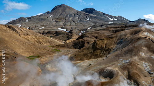 Canvastavla Steam rises from a geothermal vent beneath snow-streaked peaks at Kerlingarfjoll in the Icelandic Highlands, surrounded by rugged rhyolite mountains and valleys