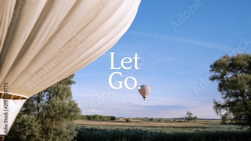 A tranquil scene in the sky featuring a hot air balloon gracefully drifting over vibrant green fields representing liberation and the spirit of release