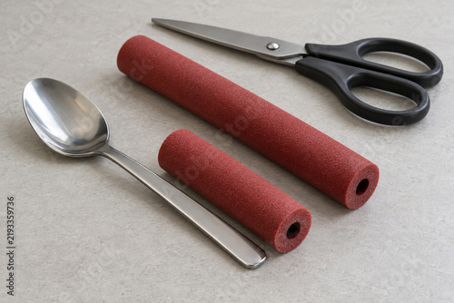 Cut foam tubing beside a spoon for preparing a built-up handle