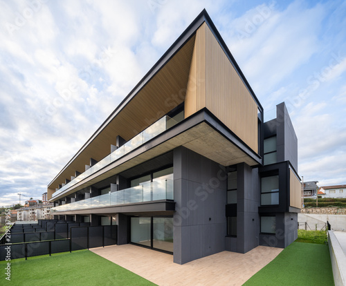 Modern hillside residential apartment building with glass balconies