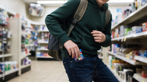 Obraz na płótnie 店舗で商品をポケットに入れ万引きする人物のイメージ