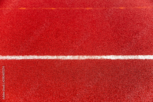 Red stadium track surface with white football field line