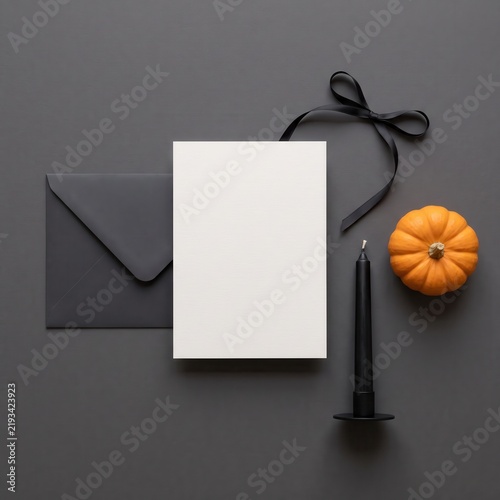 Halloween invitation mockup with blank white card, black envelope, candle, ribbon and pumpkin