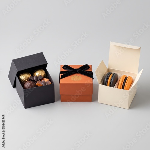 Halloween treat gift boxes with chocolates, macarons and festive packaging