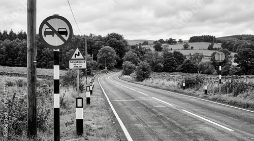 Winding Rural Road With Warning Signs and Verdant Hills