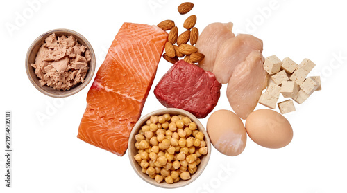 Protein rich food assortment featuring fresh salmon fillet raw chicken breast lean beef chunk boiled eggs chickpeas almonds tofu cubes and canned tuna.