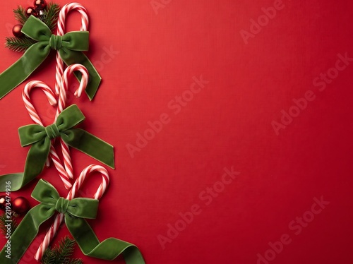 ia generated.  Festive Christmas border flat lay with pine branches, ornaments, and holiday decorations on a vibrant red background with copy space.