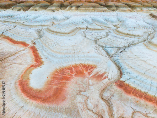 Aerial view of the colorful eroded rock formations and striated clay landscape of the Ustyurt Plateau in Mangistau, Mangystau Region, Kazakhstan.