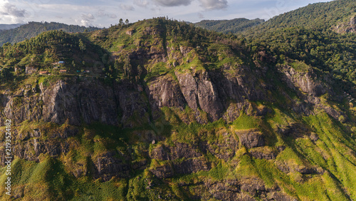 Aerial view of shola forest vegetation in Kookal, Palani Hills, Western Ghats, featuring Rudraksha, Jamun, cinnamon, grasslands, pine trees, and scattered village houses across the lush mountain lands