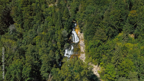 Aerial view of Le Day waterfall cascading through a dense green forest in Vallorbe, Vaud, Switzerland.