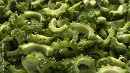 Close-up view of rotating bitter melon chunks, full-frame background texture. Bitter melon prepared for cooking, selective focus. 