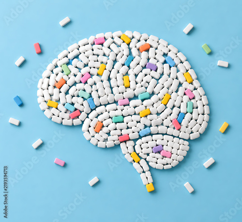 A human brain shape is constructed from numerous white and colorful tablets