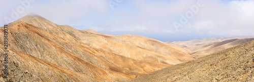Fotografía Panoramic view of arid volcanic mountains with sweeping ridges from Mirador Astronomico de Sicasumbre, Fuerteventura, Canary Islands, Spain