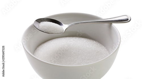 Принти на полотні Isolated view of a spoon heaped with white granulated sugar resting on a full bowl