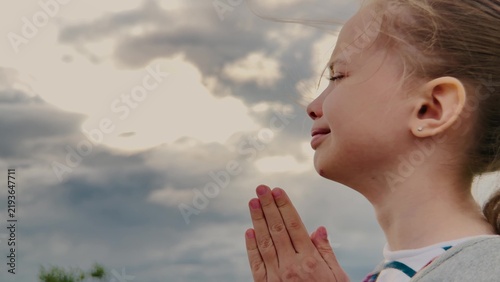 Fotografie Heart of a Child in Prayer, Girl s Gentle Faith, Praying Under a Cloudy Sky, Sil