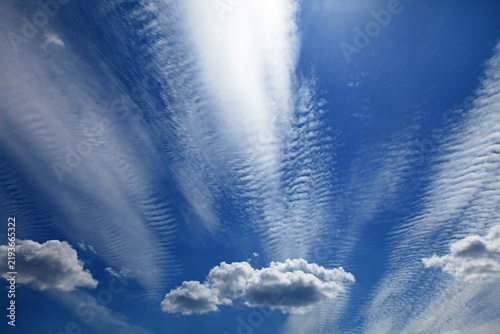 Cirrus, stratus and cumulus clouds in the same sky. Multilayer clouds pattern. Skies landscape in summer. High clouds in the backlight of the sun. Cloud layer. Clouds, atmosphere and weather formation