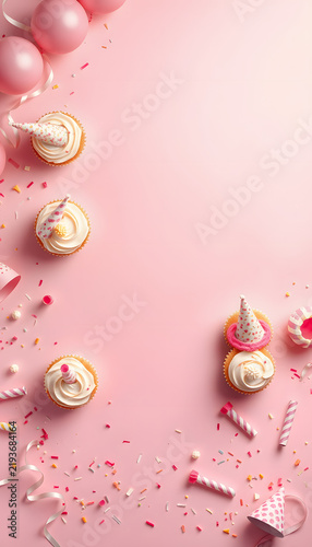 Birthday party corner border on a pastel pink banner background. Overhead view with cakes, party hats and confetti. Copy space, studio lighting. White tone